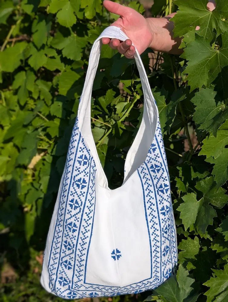 Geantă rustică din pânză albă cu flori albastre, brodate în stil tradițional, din colecția de Sânziene