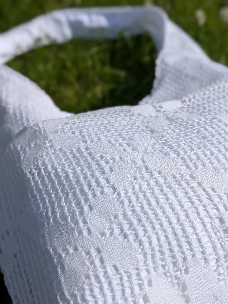 Detaliu geantă rustică din pânză albă cu flori geometrice, brodate în stil tradițional, din colecția de Sânziene