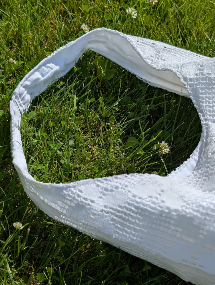 Detaliu geantă rustică din pânză albă cu flori geometrice, brodate în stil tradițional, din colecția de Sânziene